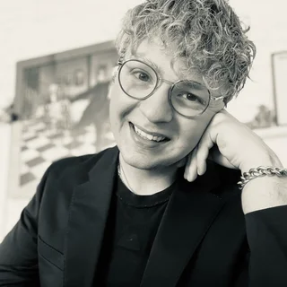 Justin Brindöpke, Psychologischer Berater, lächelt freundlich in die Kamera. Er trägt ein dunkles Hemd und strahlt Vertrauen und Professionalität aus.
